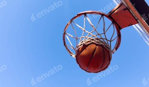 Preview: Basketball scoring a basket as it goes through the hoop and making a swish in the net