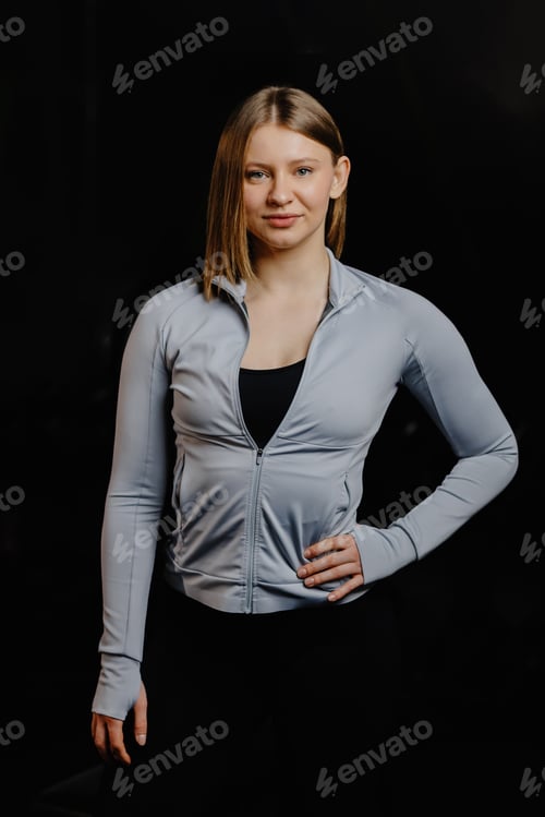 Preview: Confident athlete posing with hand on hip against black background