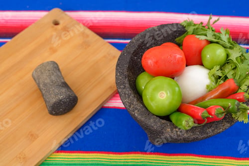 Preview: Molcajete with vegetables on a colorful serape. Ingredients for a hot sauce.