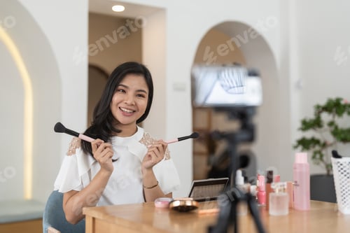 Preview: Asian female beauty blogger live streaming to review makeup product on social media, Modern young