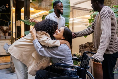 Preview: Diverse group of friends happily embracing outdoors, including a woman in a wheelchair
