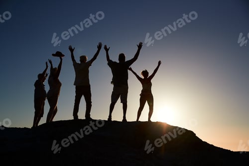 Preview: Silhouette Of Senior Friends Standing On Rocks By Sea On Vacation At Sunset With Arms Outstretched