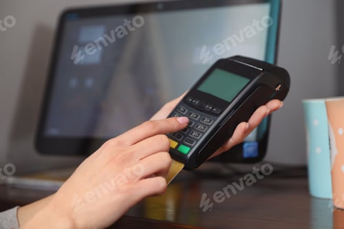Preview: Woman using credit card machine for non cash payment in cafe, closeup. Space for text