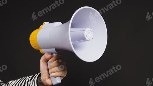 Preview: woman's hands is holding megaphone on black background.woman wear black and white stripe t shirt.