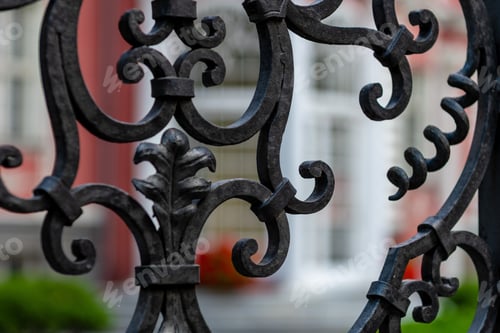 Preview: Ornate Black Ironwork Against a Blurred Building Facade