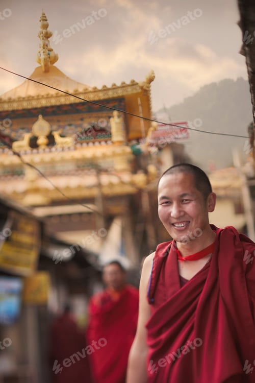 Preview: Smiling monk in traditional red robes against the backdrop of an ornate temple