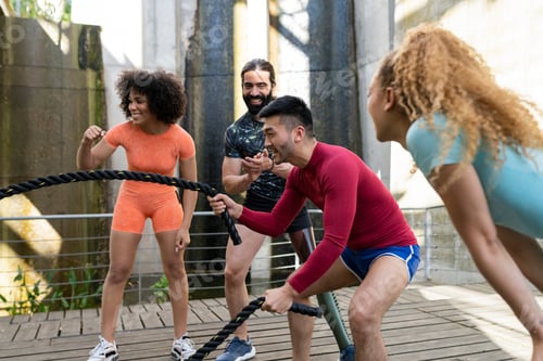 Preview: Battle rope training in training, Asian man using rope while multiracial friends