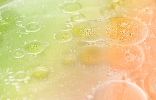 Preview: abstract lime green and orange background formed by drops of oil on water