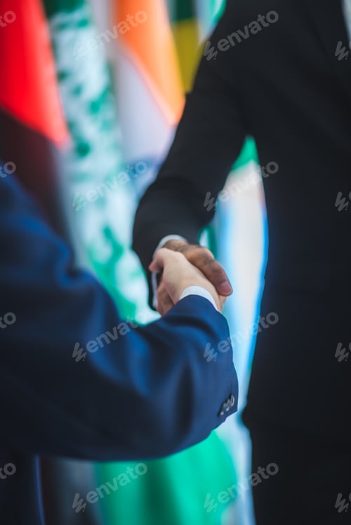 Preview: Business people shake hands, international flag background