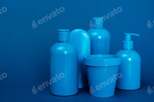 Preview: bottles with hair conditioner, shampoo, shower gel, liquid soap and bucket on blue background