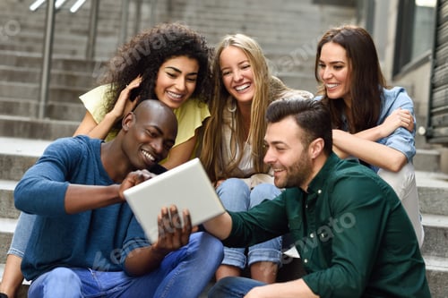 Preview: Multi-ethnic group of young people looking at a tablet computer