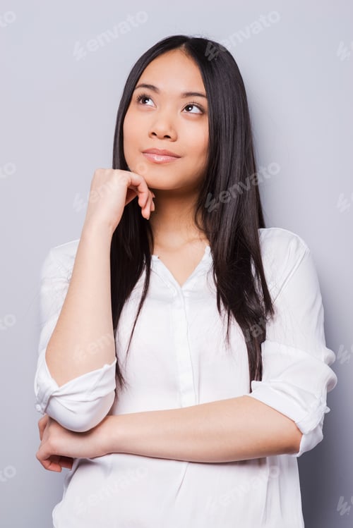 Woman Thinking with Hand on Face Wearing White