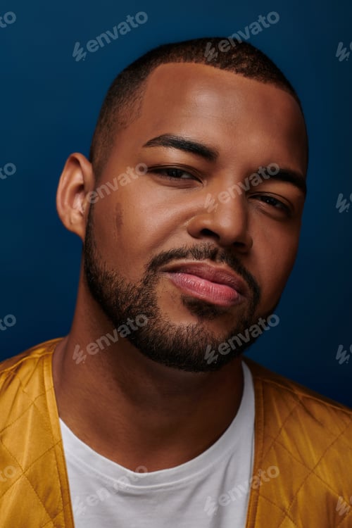 Preview: handsome african american man looking at camera and slightly smiling at camera, fashion concept