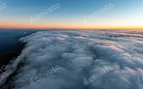 Preview: Thick layer of white clouds above mountains at sunrise