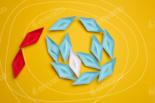 Preview: A group of colorful paper boats clustered on a yellow background