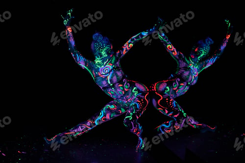 Preview: Art woman body art on the body dancing in ultraviolet light. Bright woman body neon color