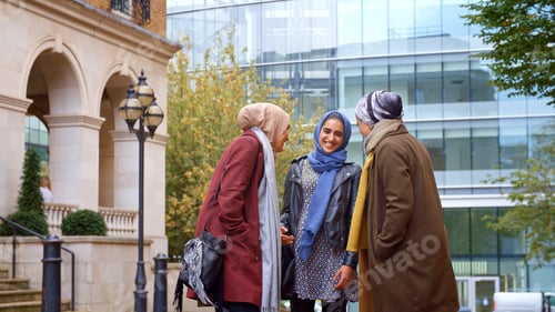 Preview: Group Of Young British Muslim Businesswomen Meeting And Talking Outside Office
