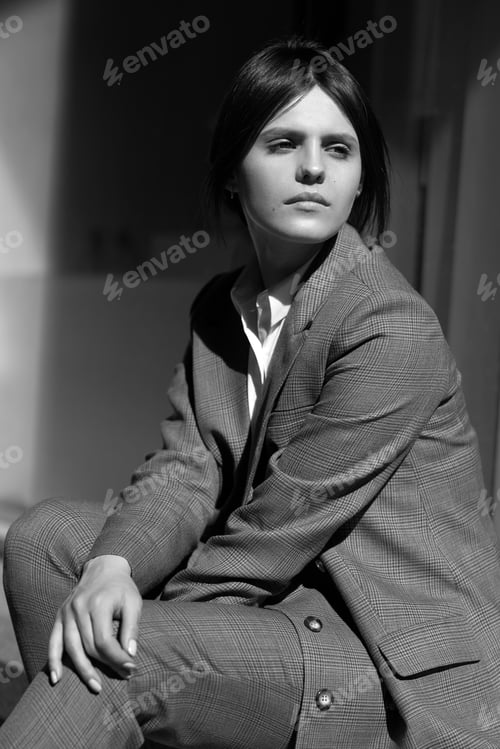 Preview: High fashion portrait of young elegant woman in brown suit walk on the street. enjoy summer lights.