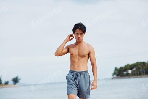 Preview: Active Asian Man Running on the Beach: Muscular Athlete Training in the Sand