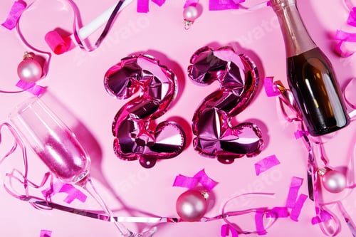 Preview: Concept of holidays and the new year. 2022 pink foil balloons, champagne, glass with pink glitter