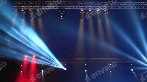 Preview: Luminous rays from concert lighting against a dark background over the projector screen