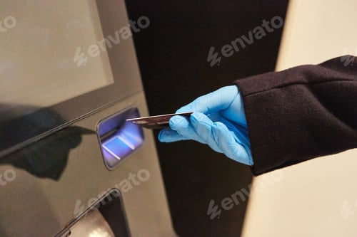 Preview: Hand In Disposable Gloves Puts Bank Card In Atm During Covid-19 Pandemic
