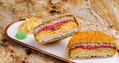Preview: Sushi sandwich with crispy coating served on a plate in a modern setting