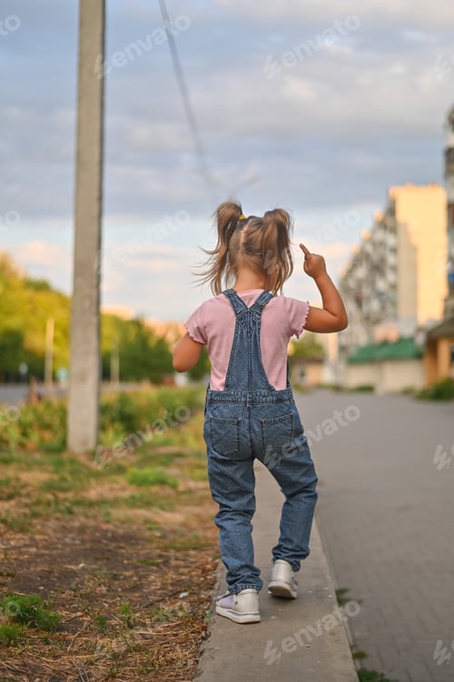 Preview: A little girl is walking on the street