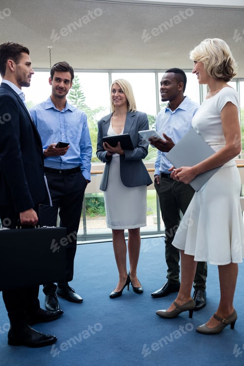 Preview: Business executives interacting in a conference center lobby