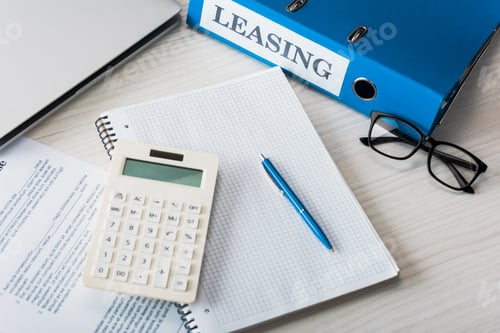 Preview: top view of folder with leasing lettering, pen, calculator and glasses near notebook on desk