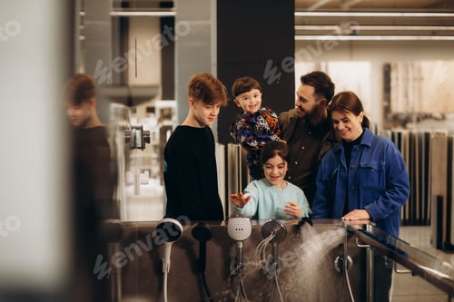 Preview: A young large family chooses a shower system in a store