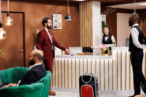 Preview: Front desk staff greets businessman