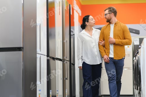 Preview: family couple buying domestic refrigerator in supermarket