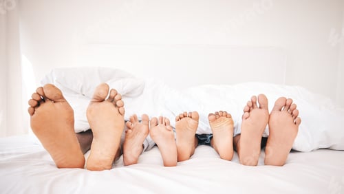 Preview: Family feet, bedroom and bed in the morning of a mother, father and young children sleeping. Mama,