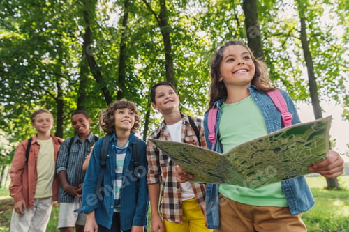 Preview: selective focus of happy kid holding map near multicultural friends