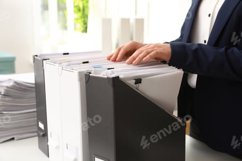Preview: Woman taking documents from folder in archive, closeup