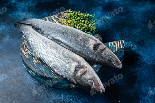 Preview: Uncooked Raw Sea Bass fish, Seabass with thyme. Blue background. Top view