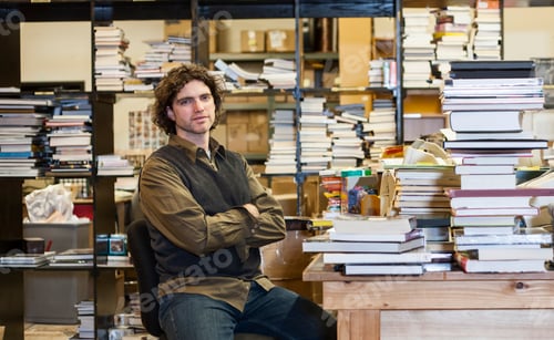 Preview: Portrait of a caucasian male employee of a bookstore working in the Used Books section of the store.