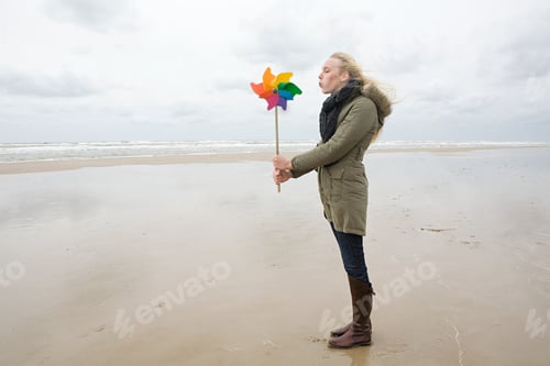 Preview: Young woman by sea with pinwheel