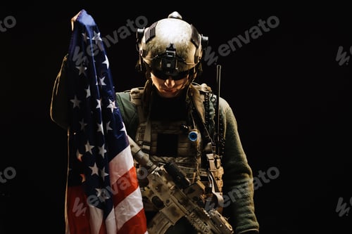 Preview: Special forces soldier holding US national flag in the dark