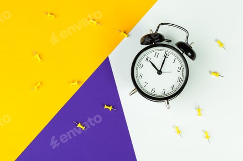 Preview: Black alarm clock on color block background, office interior