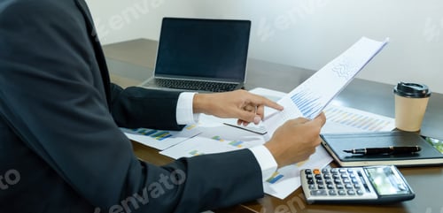 Vista previa: papel puntual con la mano del hombre, analiza el gráfico con un portátil en la oficina doméstica para establecer un objetivo desafiante