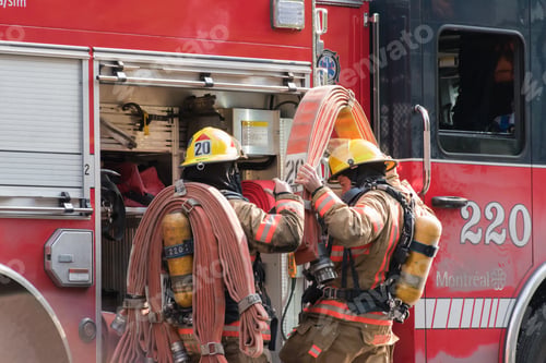 Preview: Beautiful shot of two firefighters next to the red truck getting ready for an operation