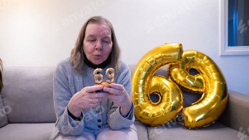 Preview: Woman blowing out 69 birthday candles