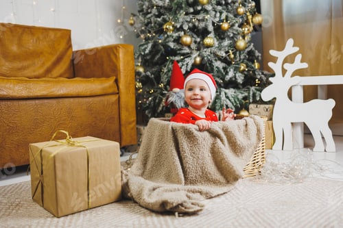 Preview: little one-year-old boy near the Christmas tree. an idea for a children's photo for the new year