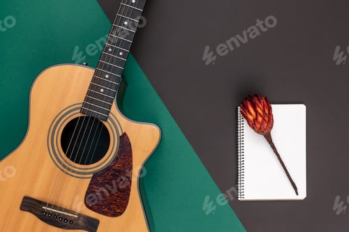 Preview: Flat lay, acoustic guitar and notebook on color background.