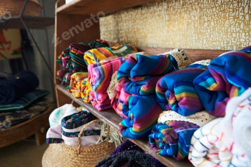 Preview: Colourful blankets displayed on shelves in a store, close up