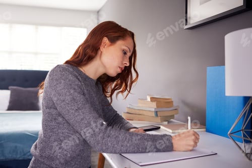 Preview: Female College Student In Shared House Bedroom Studying Sitting At Desk