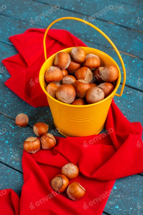 Preview: front view fresh whole hazelnuts inside yellow basket on the blue desk nut snack photo color