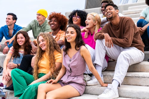 Preview: Happy playful multiethnic group of young friends bonding outdoors